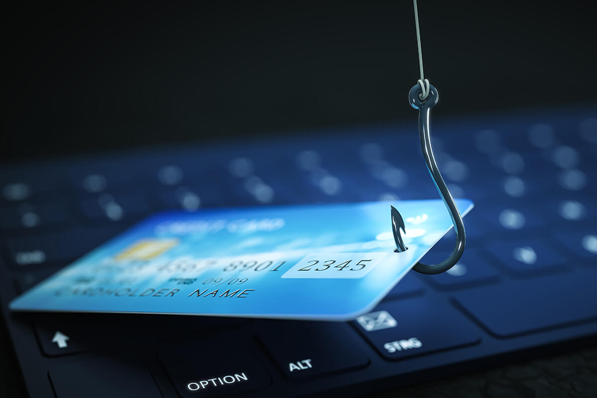 Symbolbild für Betrug: Kreditkarte an einem Angelhaken auf einer Computertastatur, Fotocredit iStock.com / magann Phishing von Kreditkartendaten