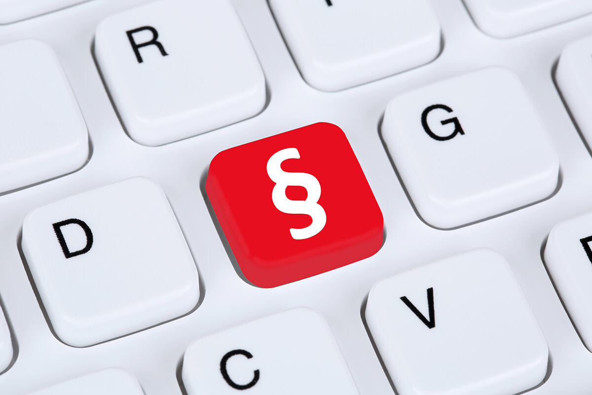 Symbolbild für Andere Strafanzeige: Weiße Tastatur mit einer roten Taste mit weißem Paragraphenzeichen, Fotocredit iStock.com / Boarding1Now Tastatur mit Paragraphenzeichen