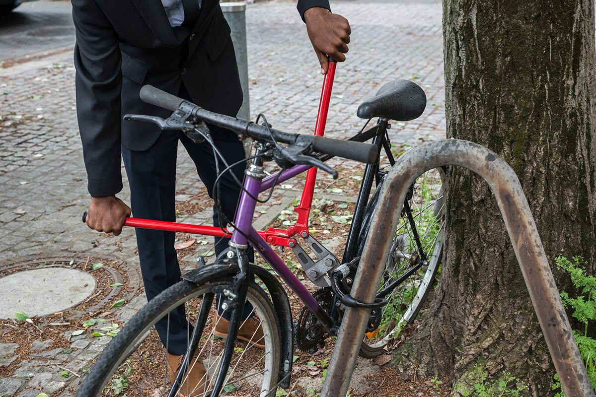 Abgesperrtes Fahrrad und Dieb mit Zange