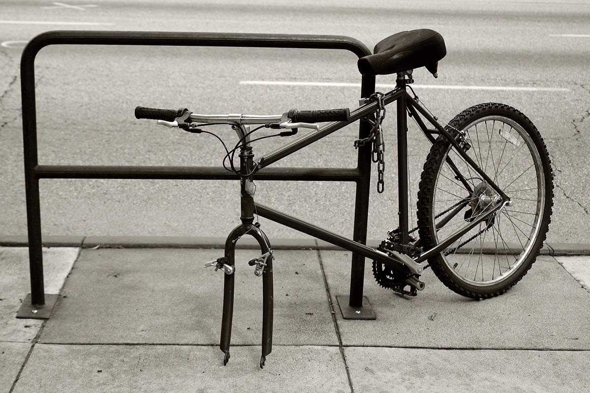 Symbolbild für Diebstahl: Mit einer Kette an einem Fahrradständer gesichertes Herrenfahrrad mit fehlendem Vorderrad, Fotocredit iStock.com / kai813 Abgesperrtes Fahrrad mit fehlendem Vorderrad